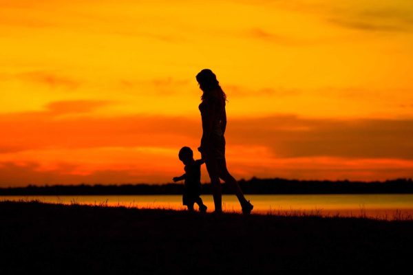 Mother with child looking at the beautiful sunset