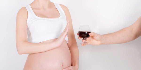 Beautiful young pregnant woman / teenager refuses to drink a wine